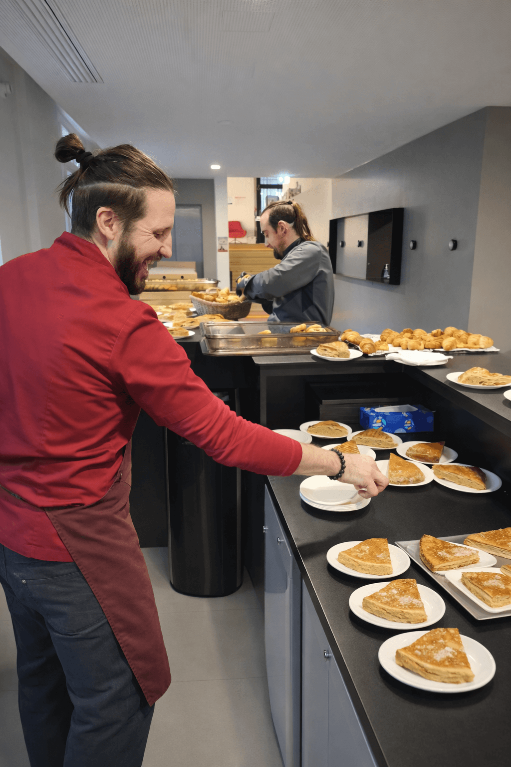 Équipe traiteur qui installe un buffet de petit déjeuner en entreprise